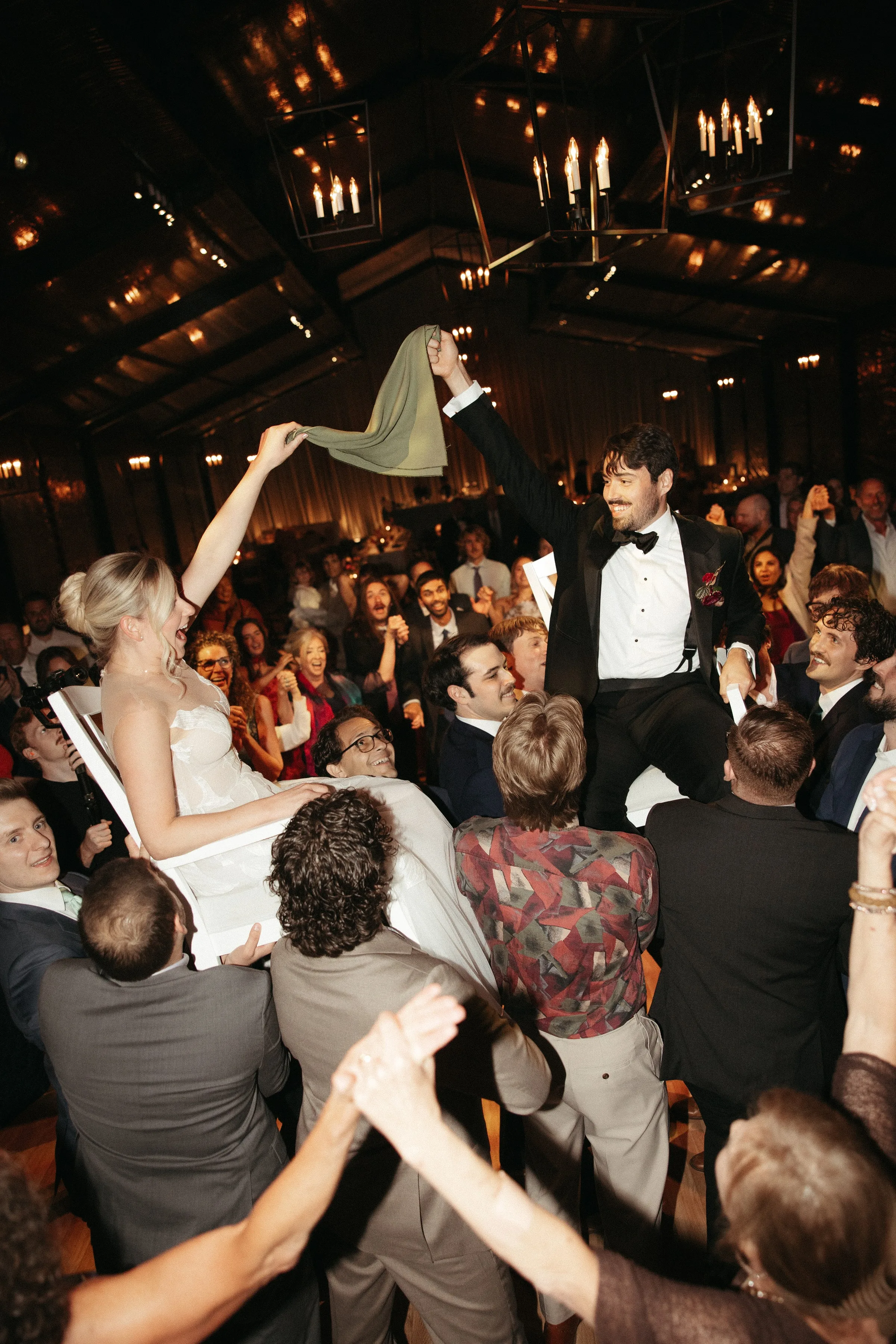 Bride and groom lifted in chairs during the hora at a lively wedding reception in Newport RI with Soul City Band performing live
