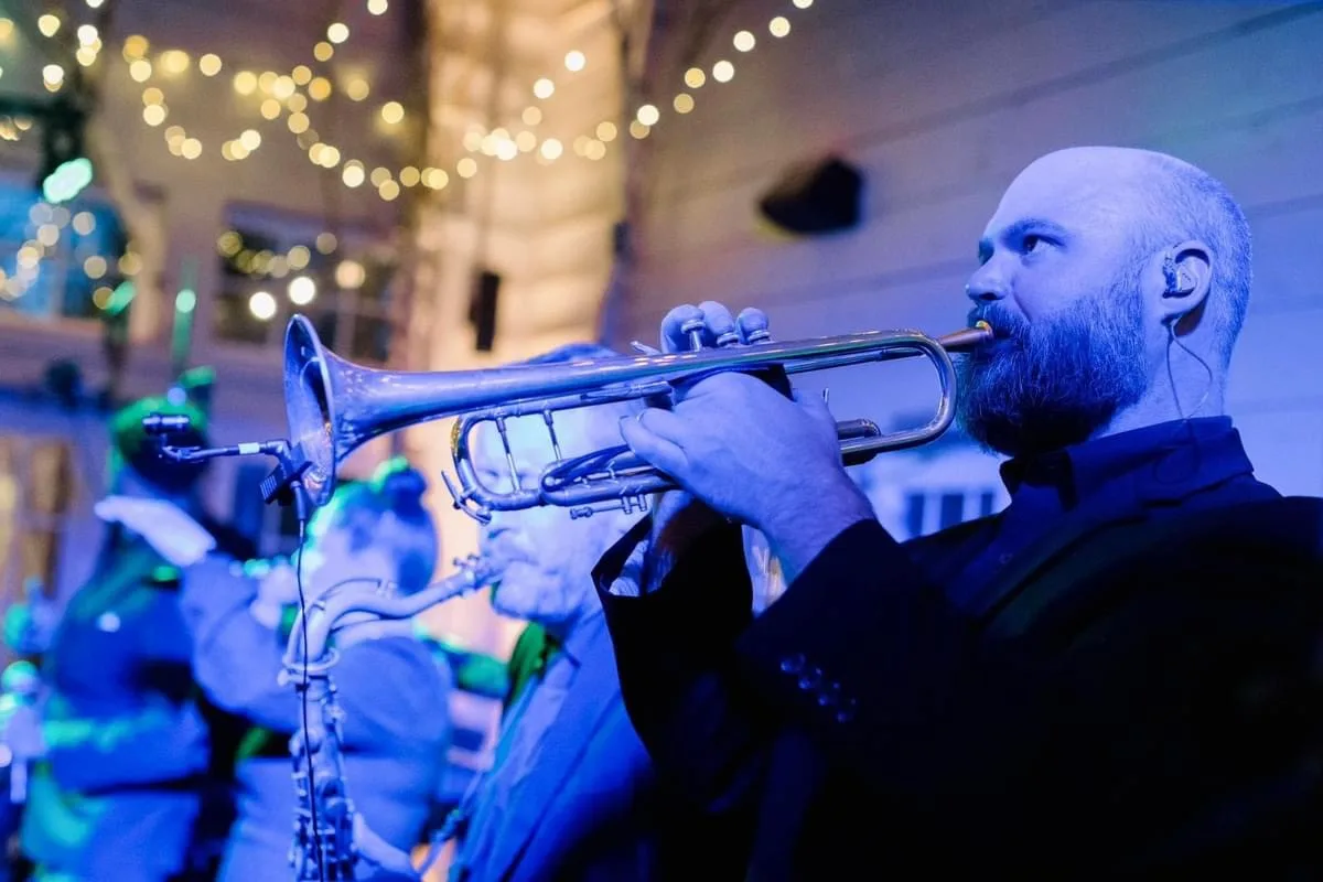 Trumpet player performing live with Soul City Band at a wedding reception under string lights in Newport RI