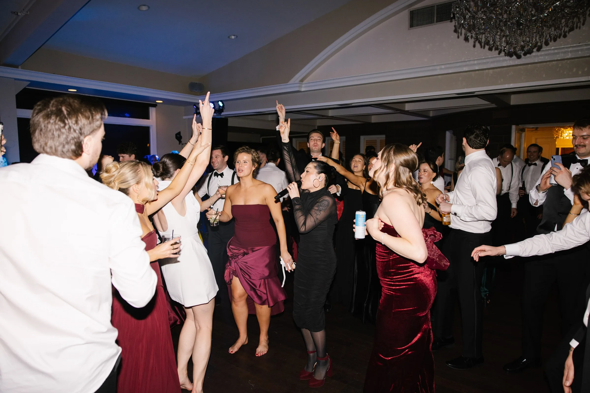 Energetic wedding reception dance floor packed with guests dancing and singing along to Soul City Band at a formal venue in Newport, Rhode Island