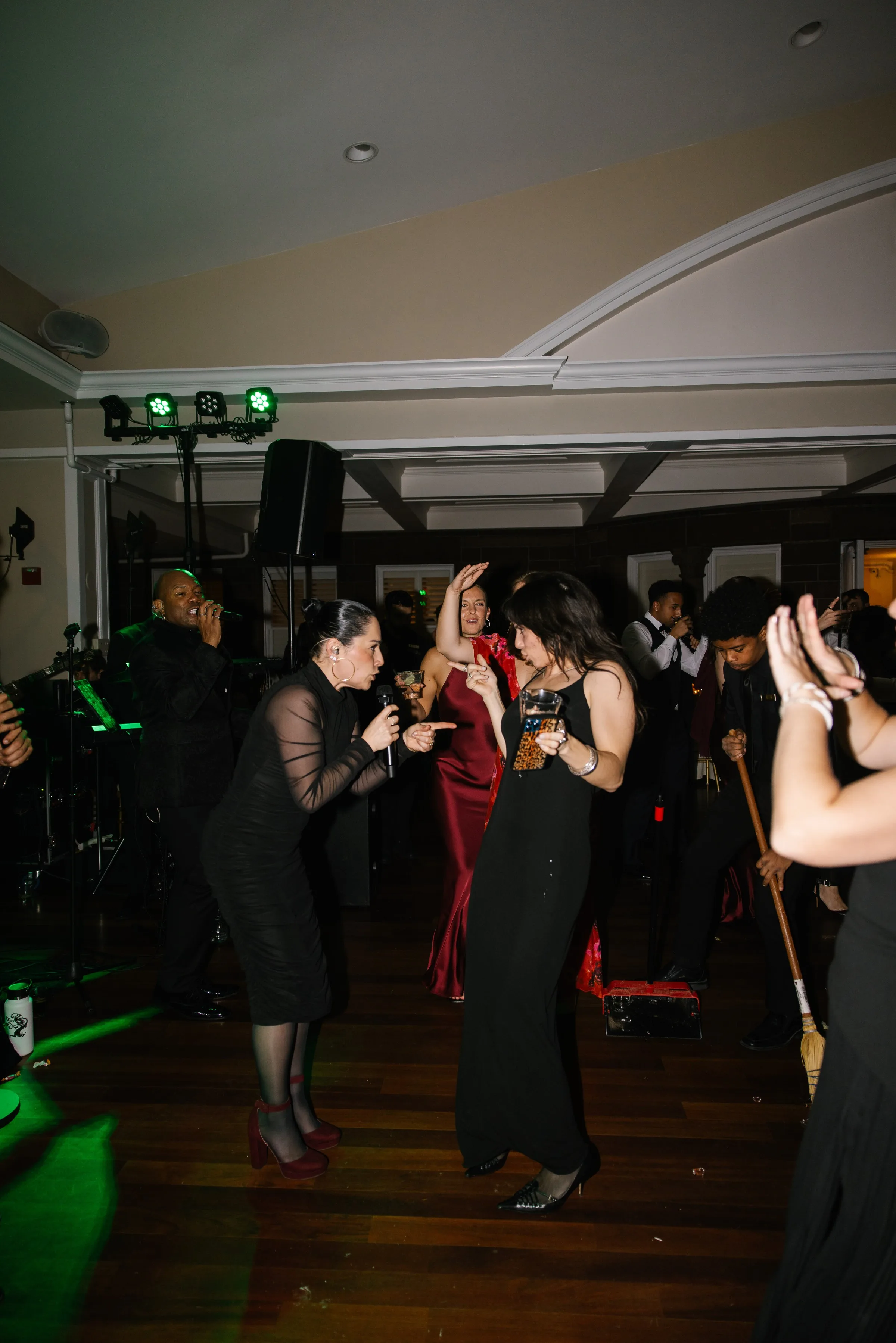 Guests dancing to Soul City Band live performance at a wedding reception in Newport RI with green stage lighting and a live vocalist on the dance floor