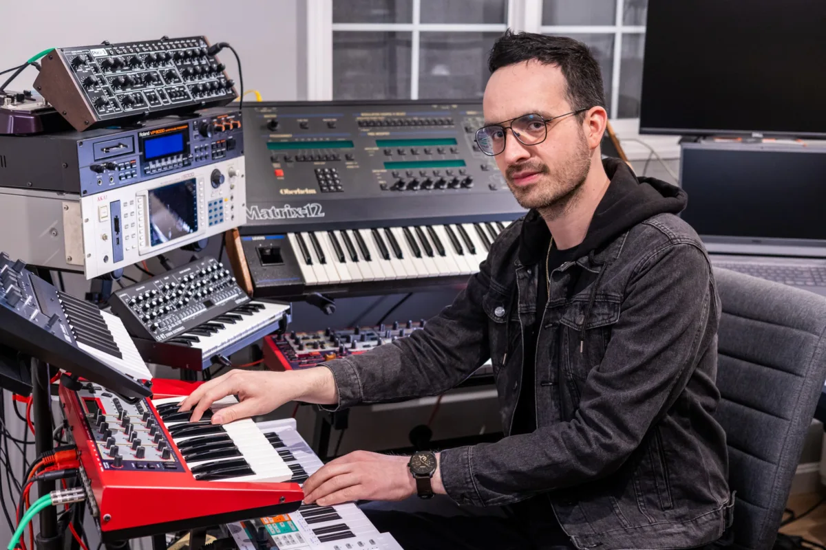 Santi Bosch, keyboardist for Soul City Band, playing synthesizers in a professional music studio surrounded by vintage keyboards and electronic instruments, available for weddings and events in Newport RI and Boston MA