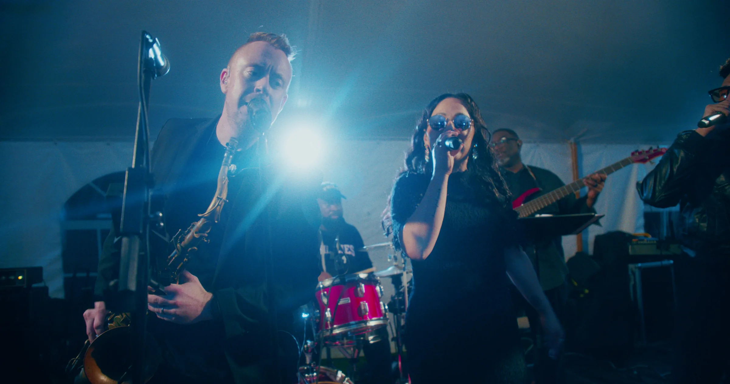 Soul City Band performing live with saxophonist and vocalist singing into microphone at an evening event in Newport RI