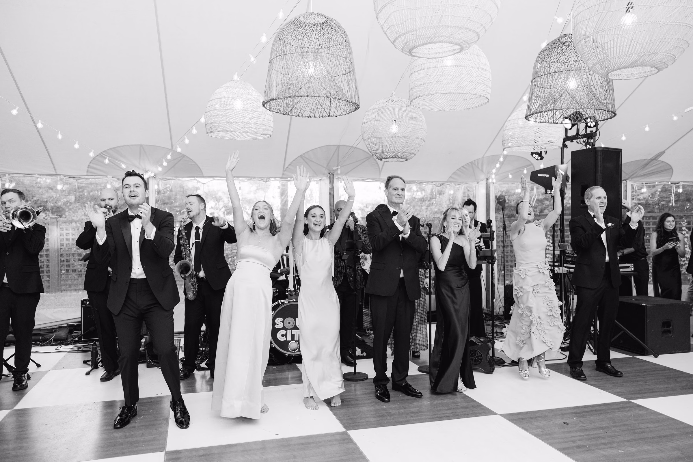 Soul City Band performs live at an elegant tented wedding reception in Newport Rhode Island as the bride and wedding guests cheer and celebrate on a checkered dance floor