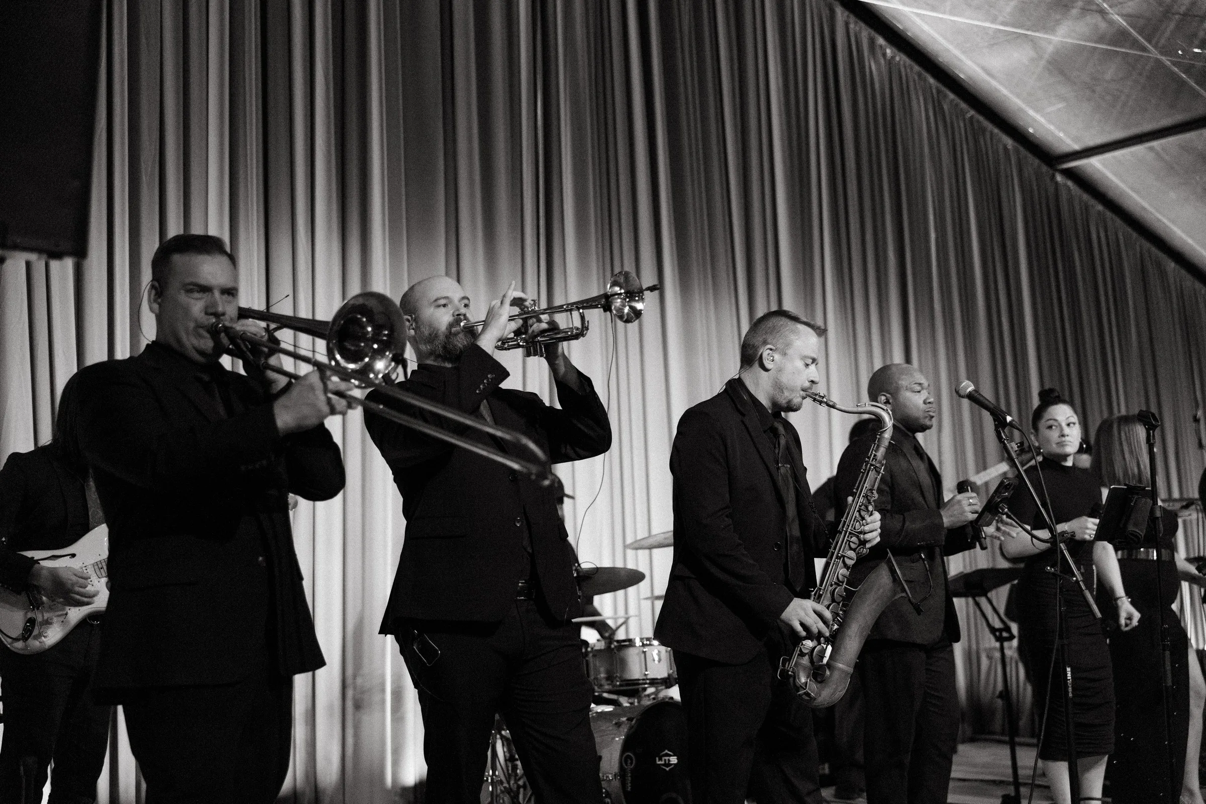 Soul City Band performing live at a wedding reception with horn section, saxophone, guitar, and vocalists dressed in black formal attire, available for weddings in Newport RI and Boston MA