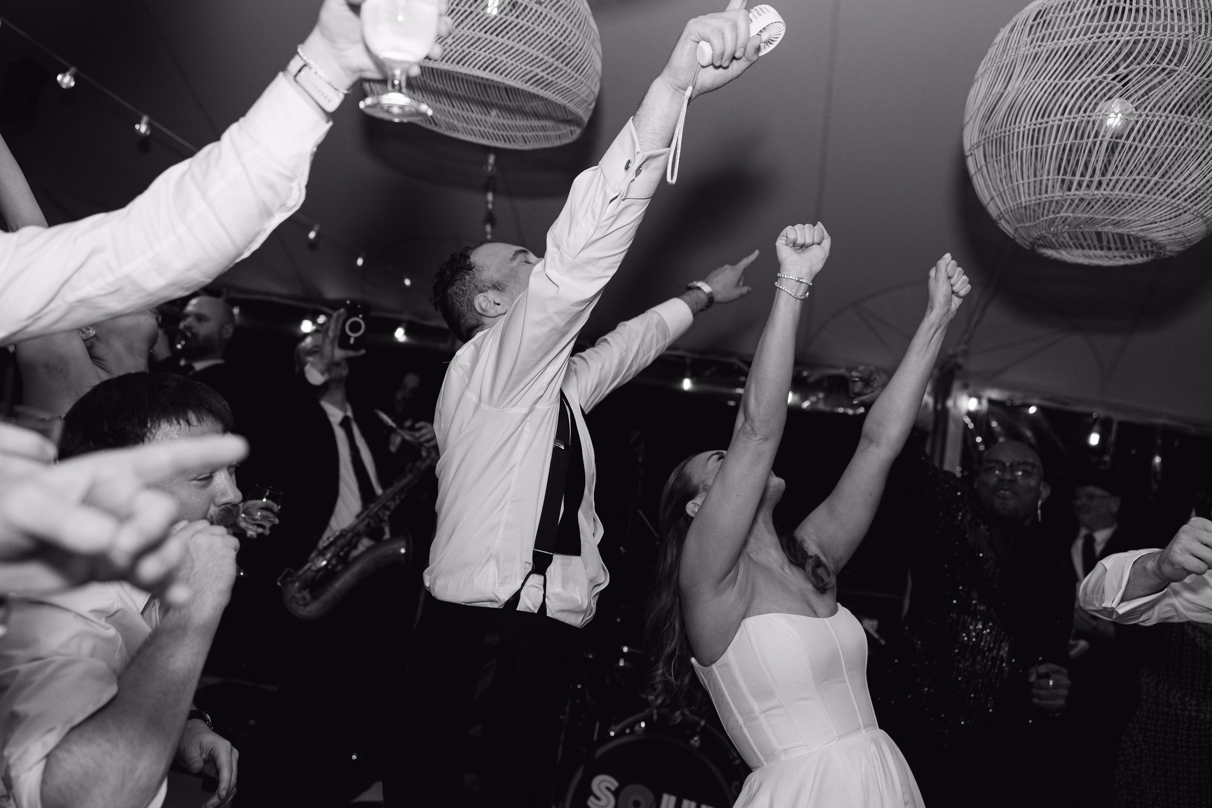 Bride and groom dancing with arms raised at an energetic wedding reception with Soul City Band performing live in Newport Rhode Island