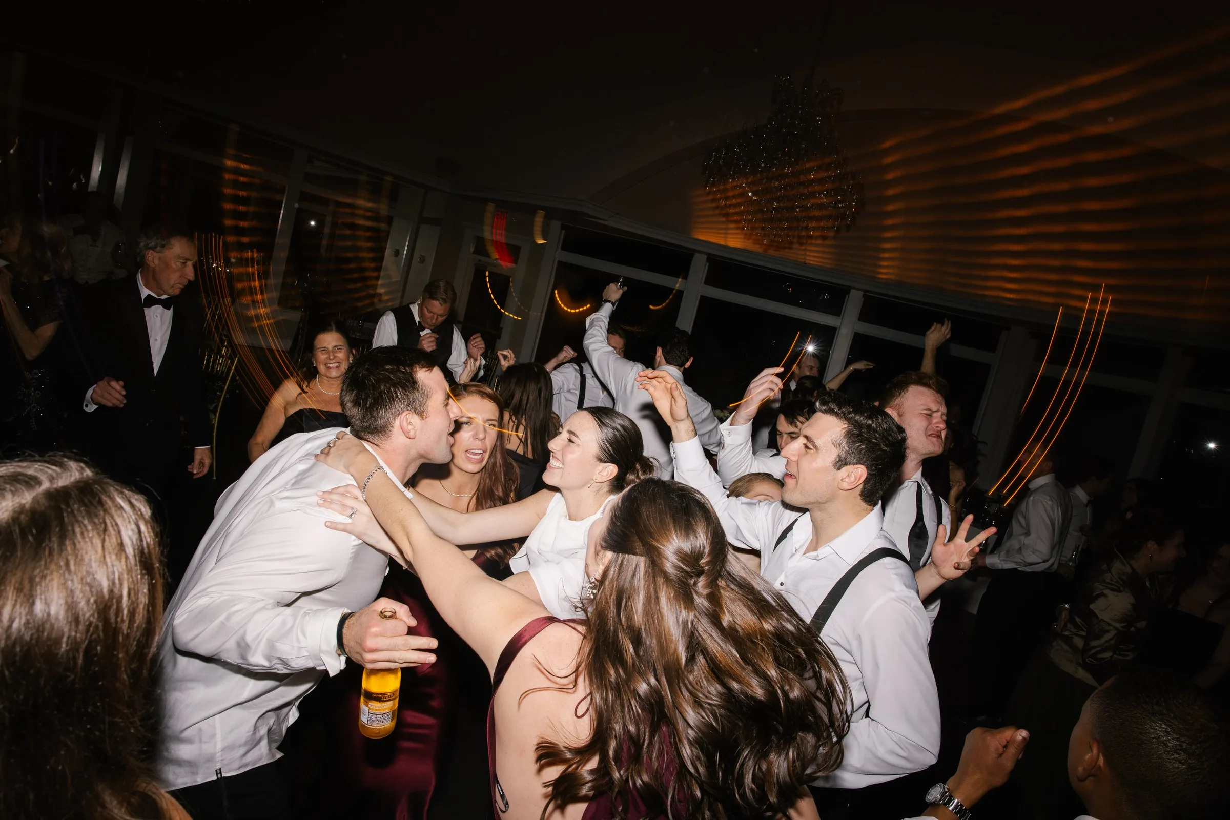 Guests celebrating and dancing at a lively wedding reception dance floor, energized by live band entertainment in Newport RI or Boston MA